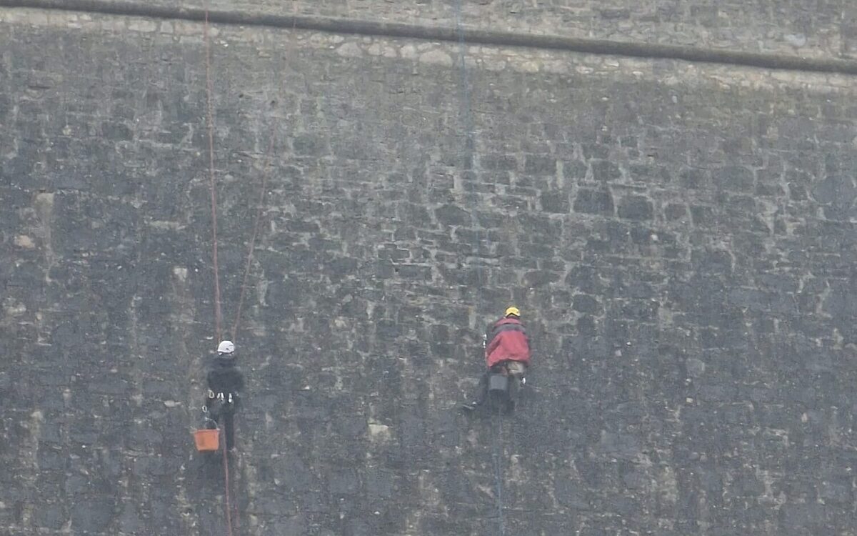 Arbeiter klettern an der Festungsmauer entlang Arbeiter klettern an der Festungsmauer entlang