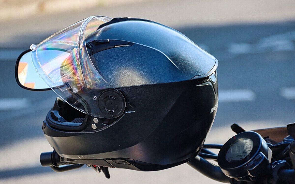 Ein Helm an einem Motorradlenker Ein Helm an einem Motorradlenker