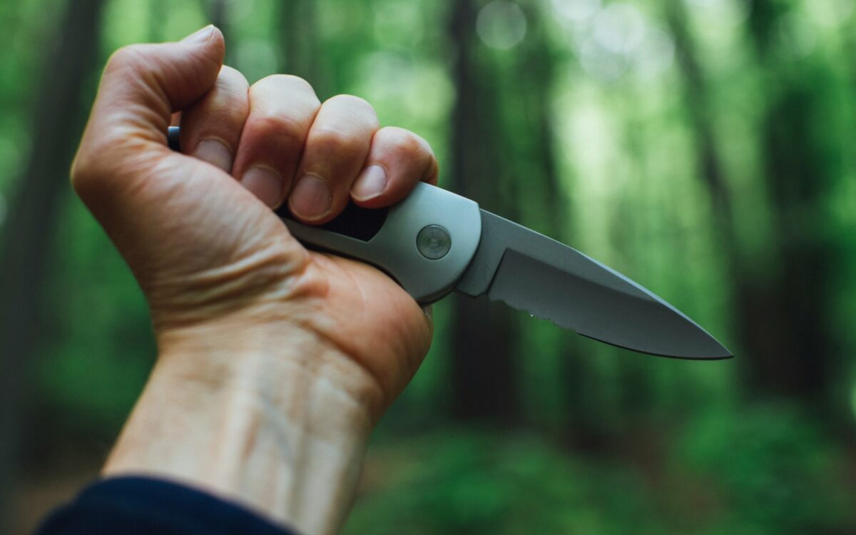 Ein Mann hält ein Messer in der Hand Ein Mann hält ein Messer in der Hand