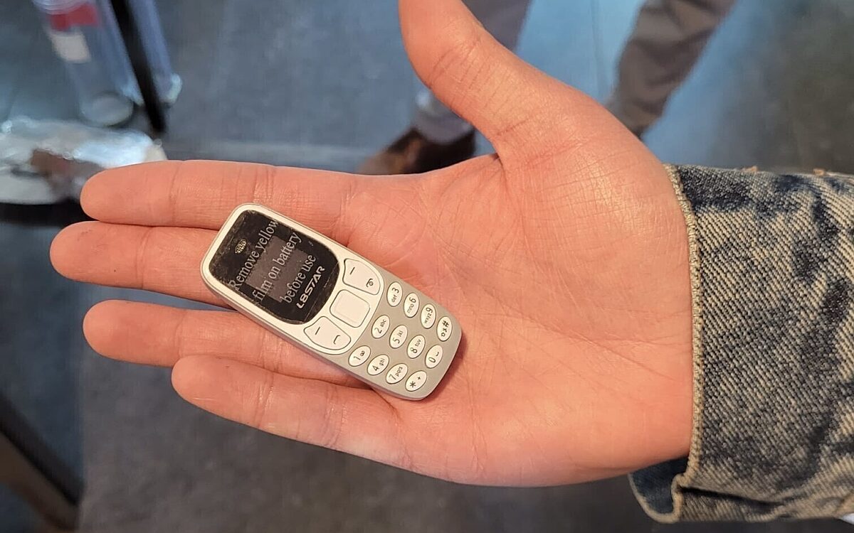 Ein Minihandy auf einer Hand Ein Minihandy auf einer Hand