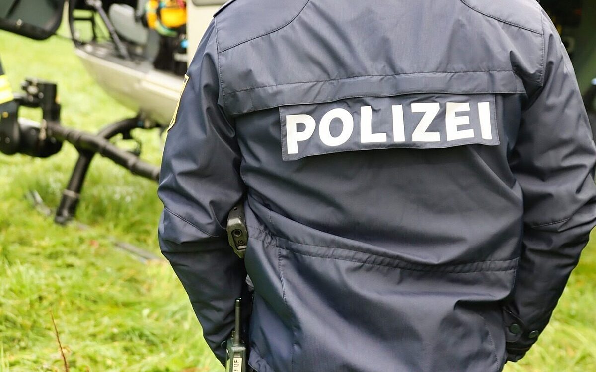 Ein Polizist steht vor einem Polizeihubschrauber Ein Polizist steht vor einem Polizeihubschrauber
