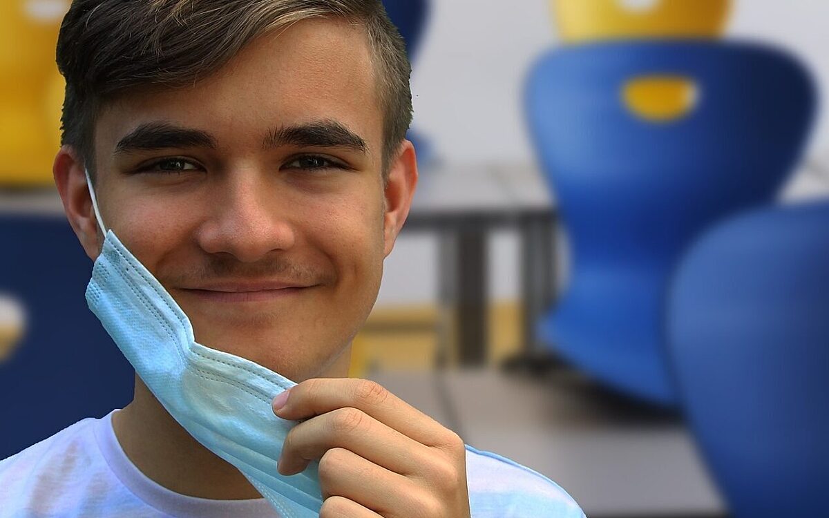 Ein Schüler nimmt seine Maske ab Ein Schüler nimmt seine Maske ab