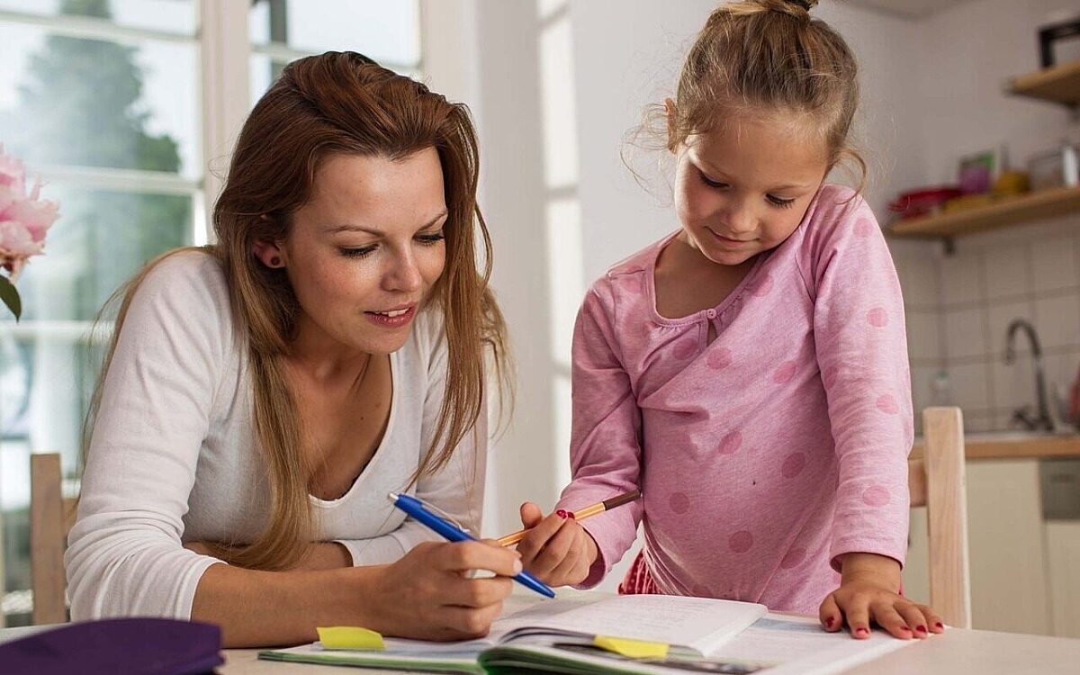 Eine Mutter macht mit ihrem Kind Hausaufgaben Eine Mutter macht mit ihrem Kind Hausaufgaben