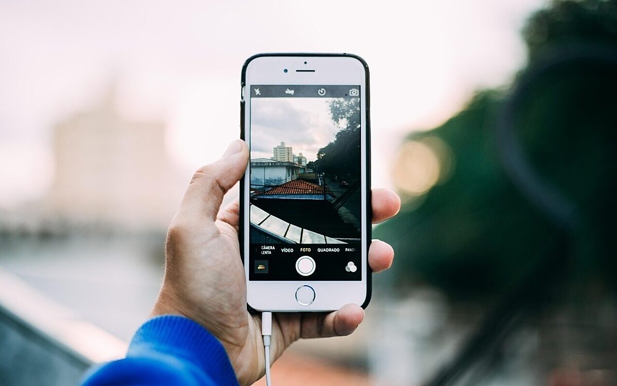 Eine Person fotografiert mit dem Handy ein Gebaeude Eine Person fotografiert mit dem Handy ein Gebaeude