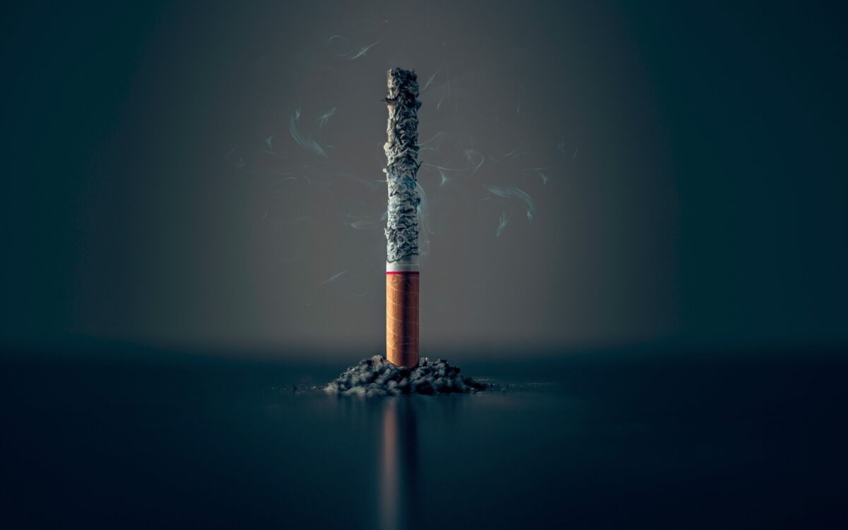 Eine Zigarette vor einem schwarzen Hintergrund Eine Zigarette vor einem schwarzen Hintergrund