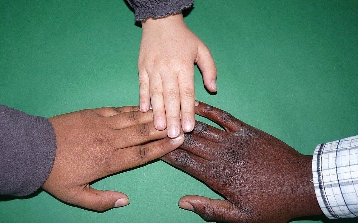 Integration Kinder legen die Hände aufeinander Integration Kinder legen die Hände aufeinander