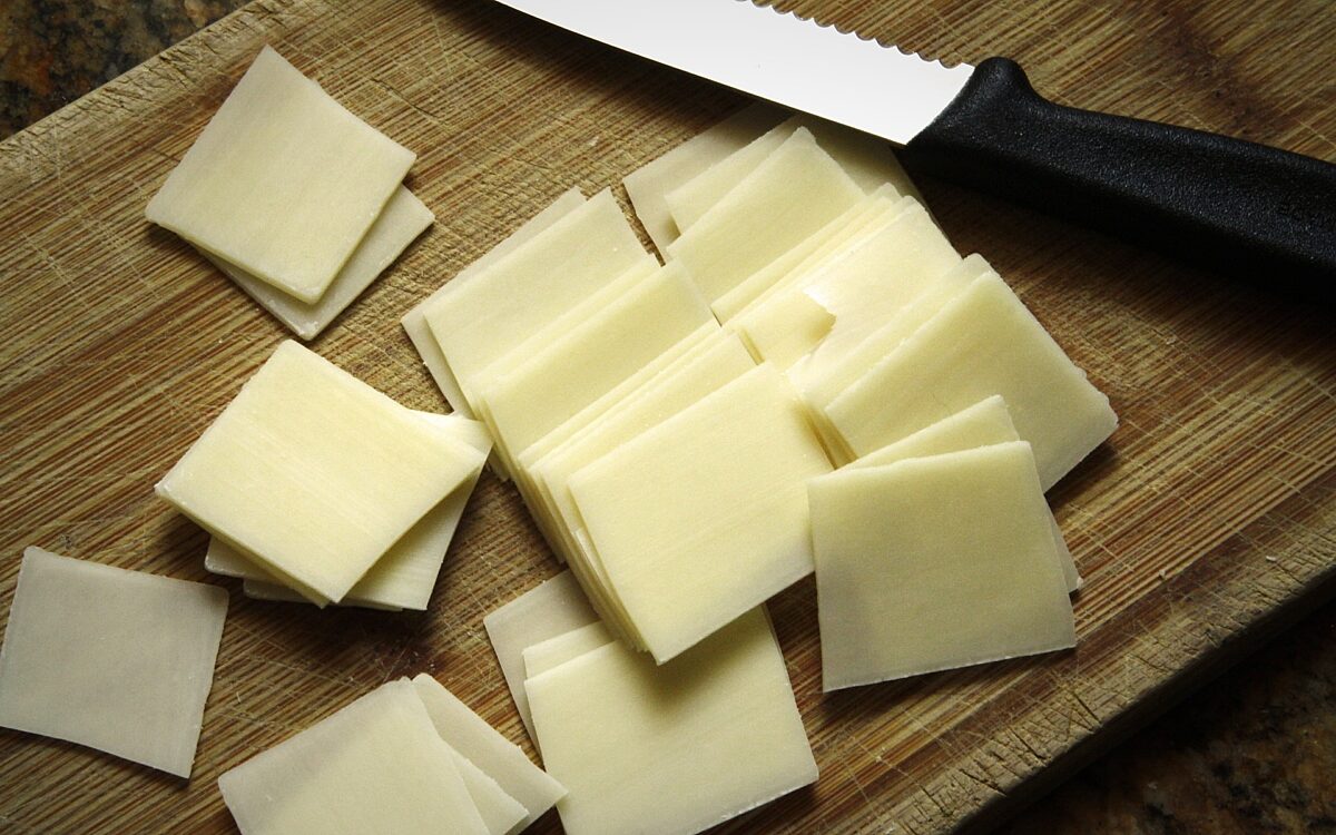 Kaese liegt mit Messer auf Brett Kaese liegt mit Messer auf Brett