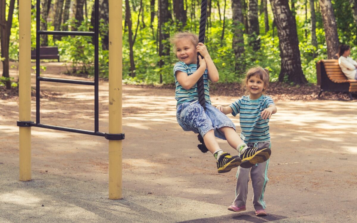 Kindergartenkinder spielen auf dem Spielplatz Kindergartenkinder spielen auf dem Spielplatz