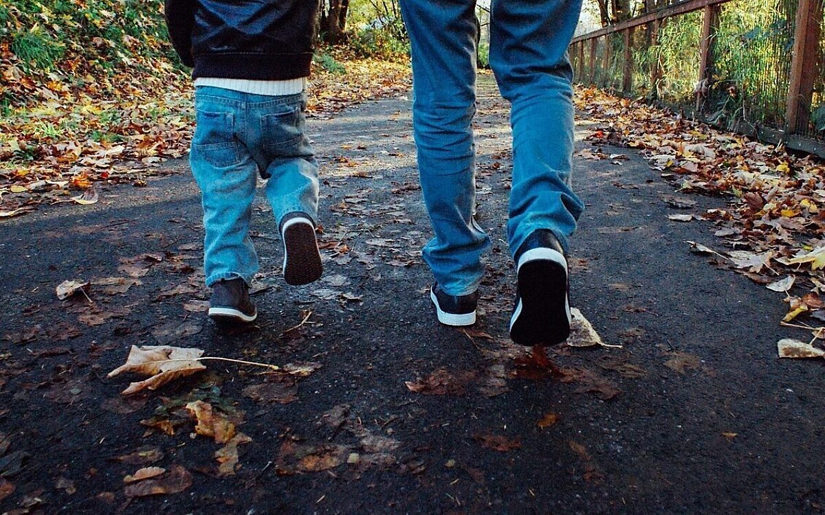 Vater und Sohn gehen durch Laub Spazieren Familie Vater und Sohn gehen durch Laub Spazieren Familie