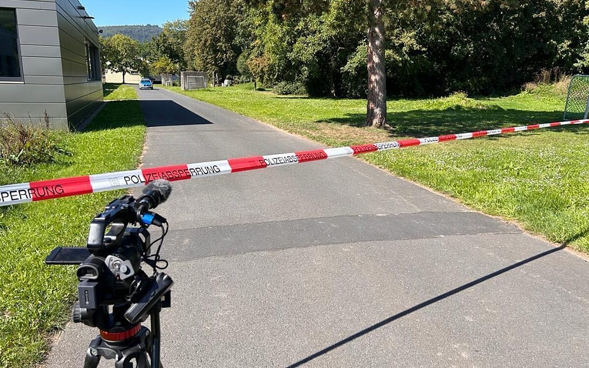 Der Tatort am Schulzentrum in Lohr ist mit einem Band der Polizei abgesperrt, eine TV-Kamera steht davor Der Tatort am Schulzentrum in Lohr ist mit einem Band der Polizei abgesperrt, eine TV-Kamera steht davor