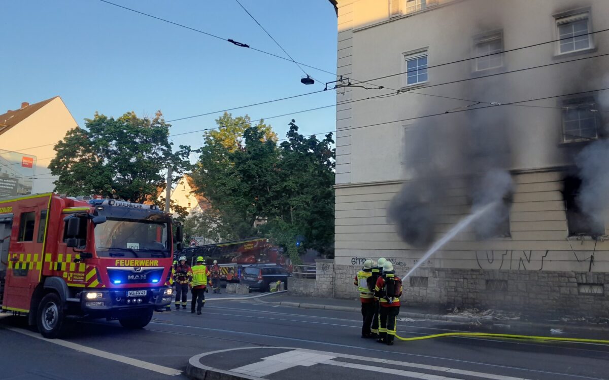 Die Feuerwehr hält den Wasserstrahl in das Fenster einer Wohnung, aus dem es stark qualmt. Die Feuerwehr hält den Wasserstrahl in das Fenster einer Wohnung, aus dem es stark qualmt.