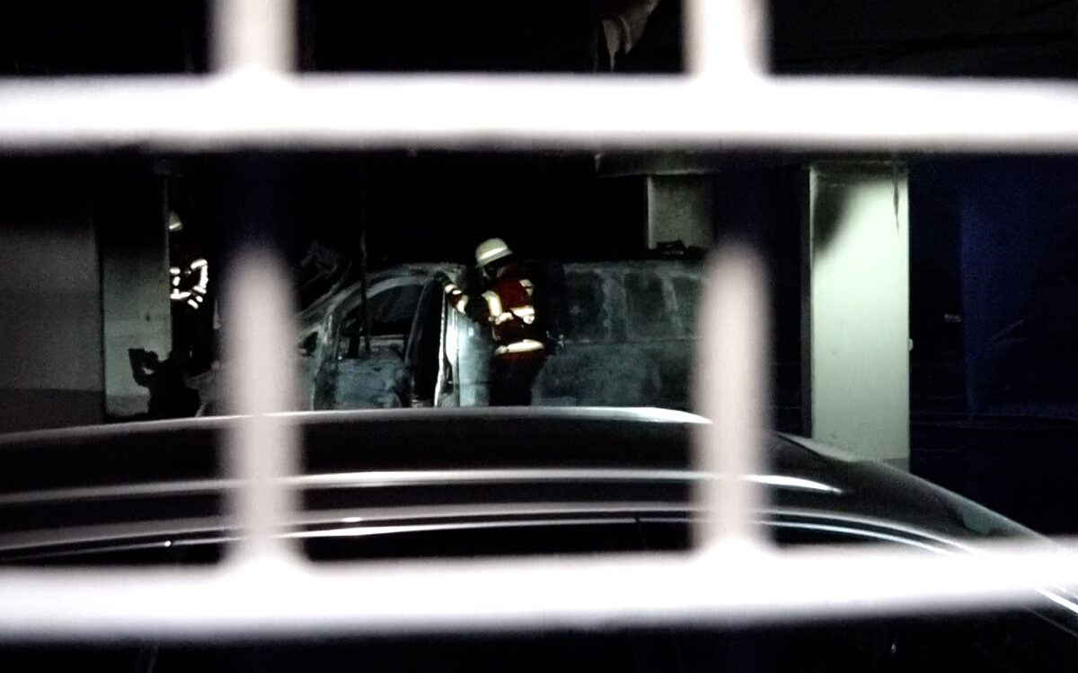 Feuerwehrleute an einem der ausgebrannten Fahrzeuge Feuerwehrleute an einem der ausgebrannten Fahrzeuge