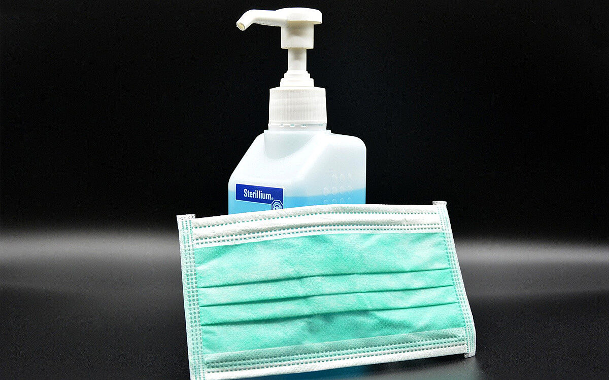 Ein Desinfektionsmittel mit Maske zum Schutz gegen das Coronavirus Ein Desinfektionsmittel mit Maske zum Schutz gegen das Coronavirus