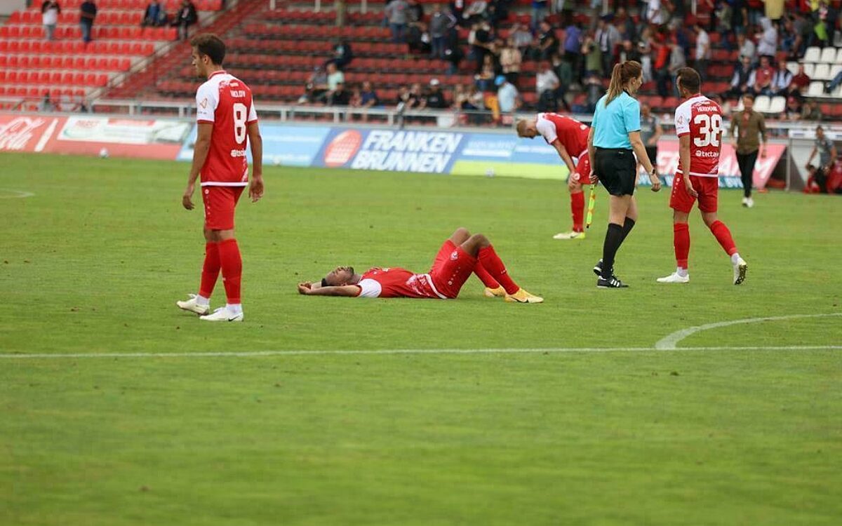 Ein kickersspieler liegt auf dem ruecken auf dem rasen der flyeralarmarena Ein kickersspieler liegt auf dem ruecken auf dem rasen der flyeralarmarena