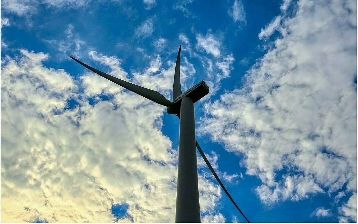 Ein windrad vor einem blauen himmel voller wolken Ein windrad vor einem blauen himmel voller wolken