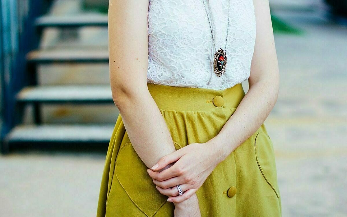 Eine frau mit gelbem rock kreuzt die arme ueber ihrer huefte Eine frau mit gelbem rock kreuzt die arme ueber ihrer huefte