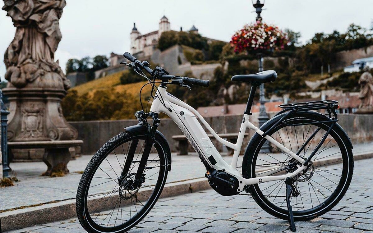 E-Bike Fahrrad auf der Alten Mainbrücke mit der Festung im Hintergrund E-Bike Fahrrad auf der Alten Mainbrücke mit der Festung im Hintergrund