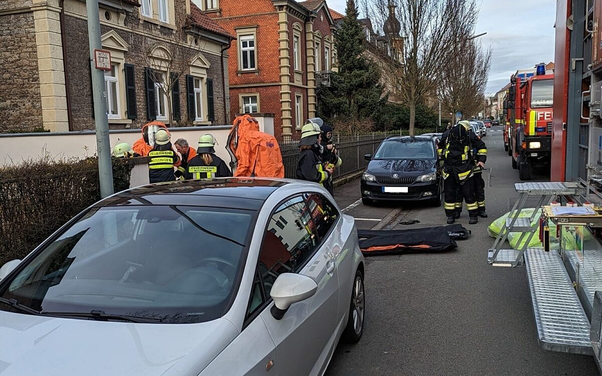 Feuerwehrleute stehen in Chemiekalienschutzanzügen am Einsatzort Feuerwehrleute stehen in Chemiekalienschutzanzügen am Einsatzort