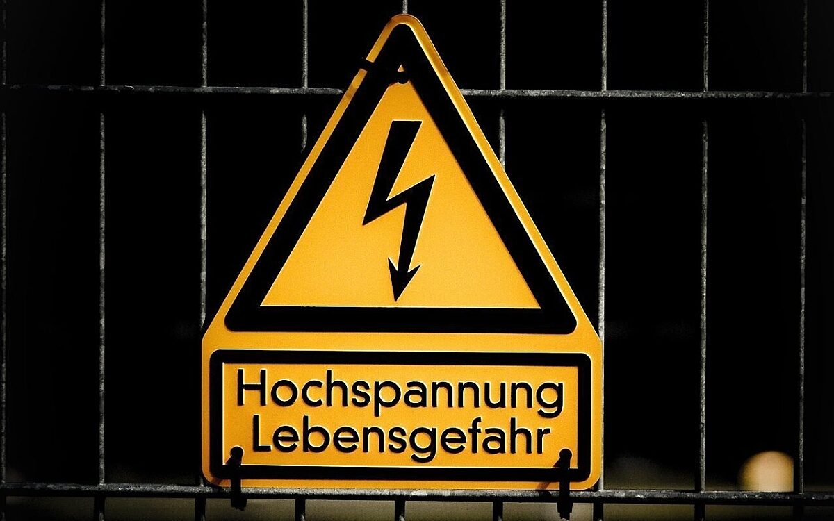 Ein Schild warnt "Hochspannung Lebensgefahr" Ein Schild warnt "Hochspannung Lebensgefahr"