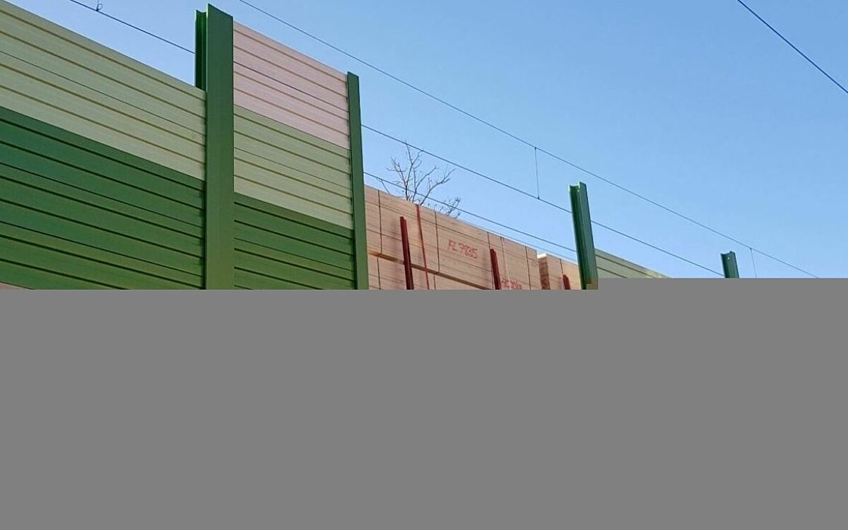 Eine Lärmschutzwand der Deutschen Bahn entlang der Gleise in grün und braun Eine Lärmschutzwand der Deutschen Bahn entlang der Gleise in grün und braun