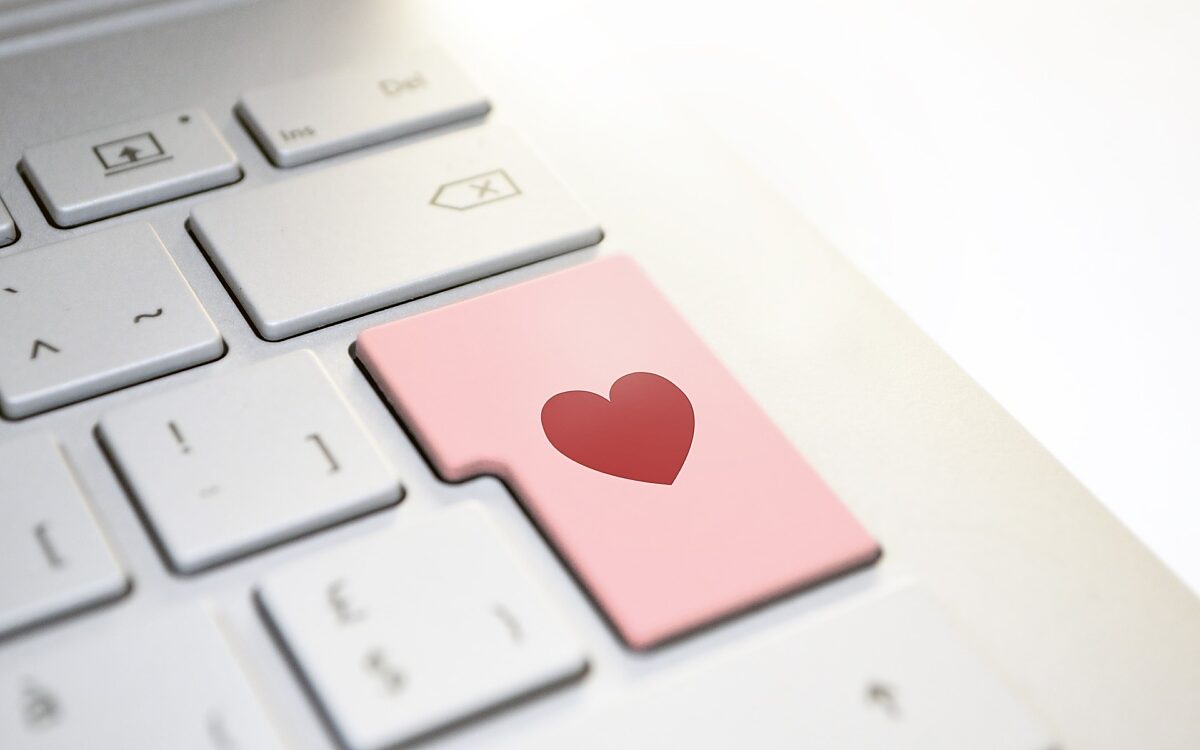 Online-Dating - eine Computertastatur mit einem roten Herz auf einer Taste Online-Dating - eine Computertastatur mit einem roten Herz auf einer Taste