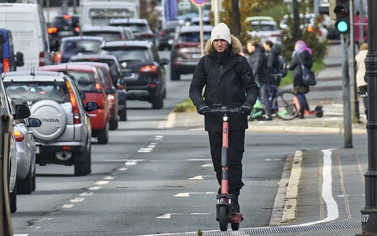Ein Mann fährt mit einem E-Scooter in der Stadt Ein Mann fährt mit einem E-Scooter in der Stadt