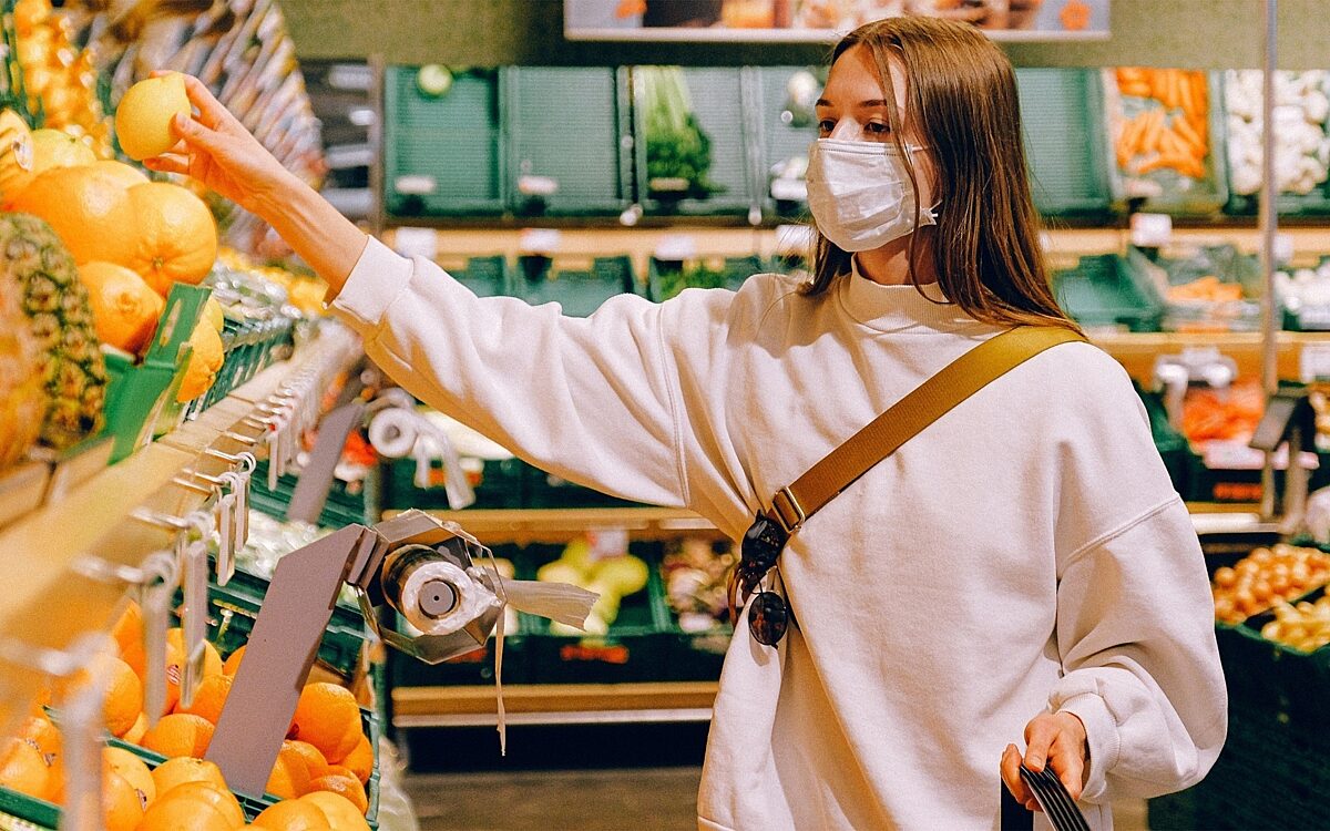 Eine Frau trägt eine Maske beim Einkauf Eine Frau trägt eine Maske beim Einkauf