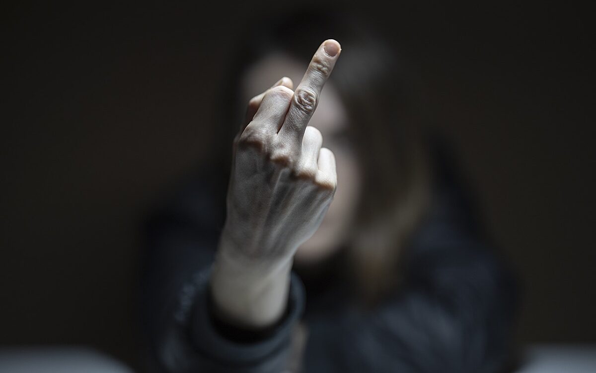 Eine Person zeigt den Mittelfinger Eine Person zeigt den Mittelfinger
