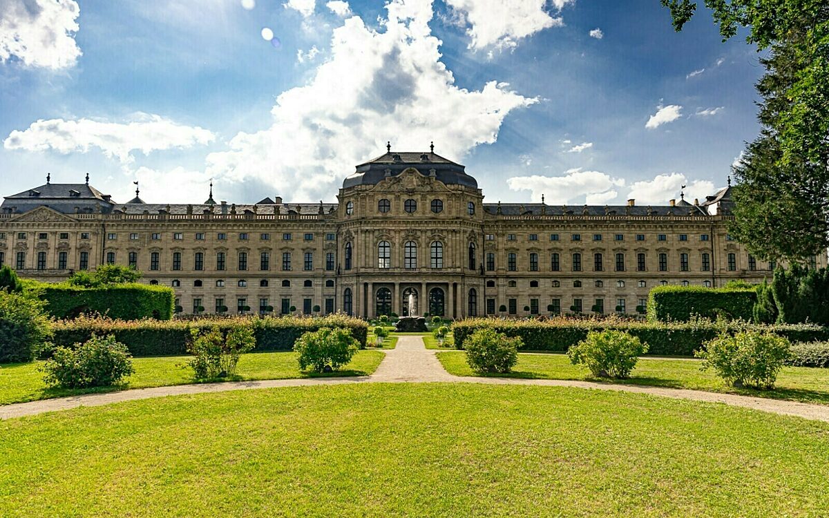 Residenz Würzburg frontal vom Residenzgarten mit Wolken bei Sonnenschein Residenz Würzburg frontal vom Residenzgarten mit Wolken bei Sonnenschein