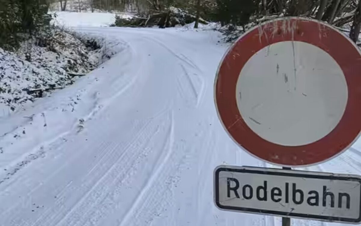 Ein Schild sperrt eine Straße ab, weil sie als Rodelbahn genutzt werden darf Ein Schild sperrt eine Straße ab, weil sie als Rodelbahn genutzt werden darf