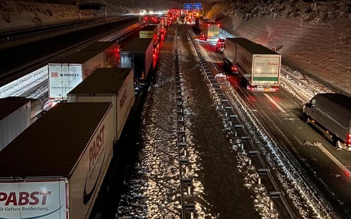 LKW stehen im Schnee im Stau auf der Autobahn LKW stehen im Schnee im Stau auf der Autobahn