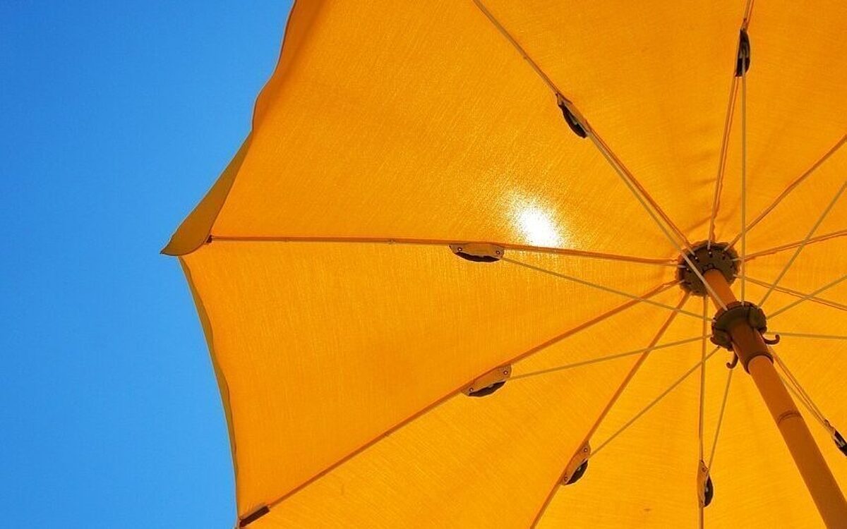 Die Sonne scheint durch einen Sonnenschirm Die Sonne scheint durch einen Sonnenschirm