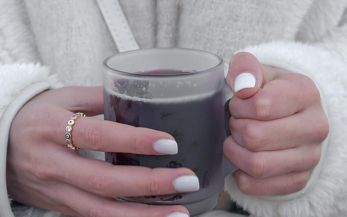 Symbolbild frau haelt gluehweintasse in der hand jpg