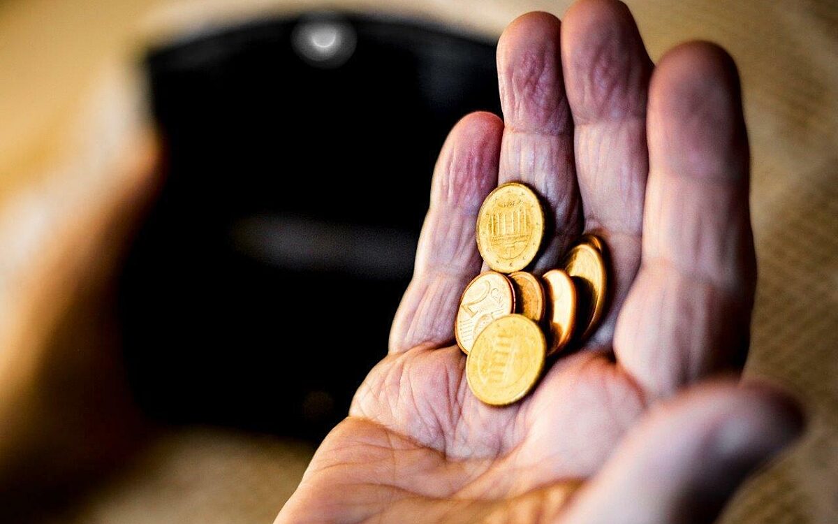 Ein Senior hat nur wenige Münzen in der Hand. Ein Senior hat nur wenige Münzen in der Hand.