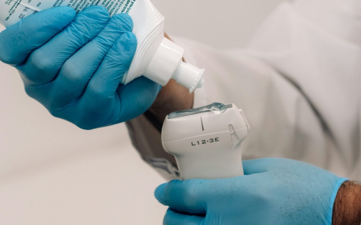 Ein Arzt trägt ein Geld auf den Ultraschall-Kopf auf. Ein Arzt trägt ein Geld auf den Ultraschall-Kopf auf.