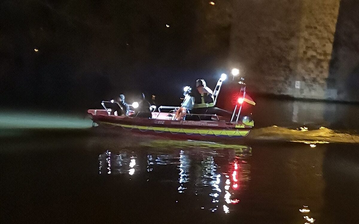 Ein Boot der Feuerwehr fährt nachts auf dem Main Ein Boot der Feuerwehr fährt nachts auf dem Main