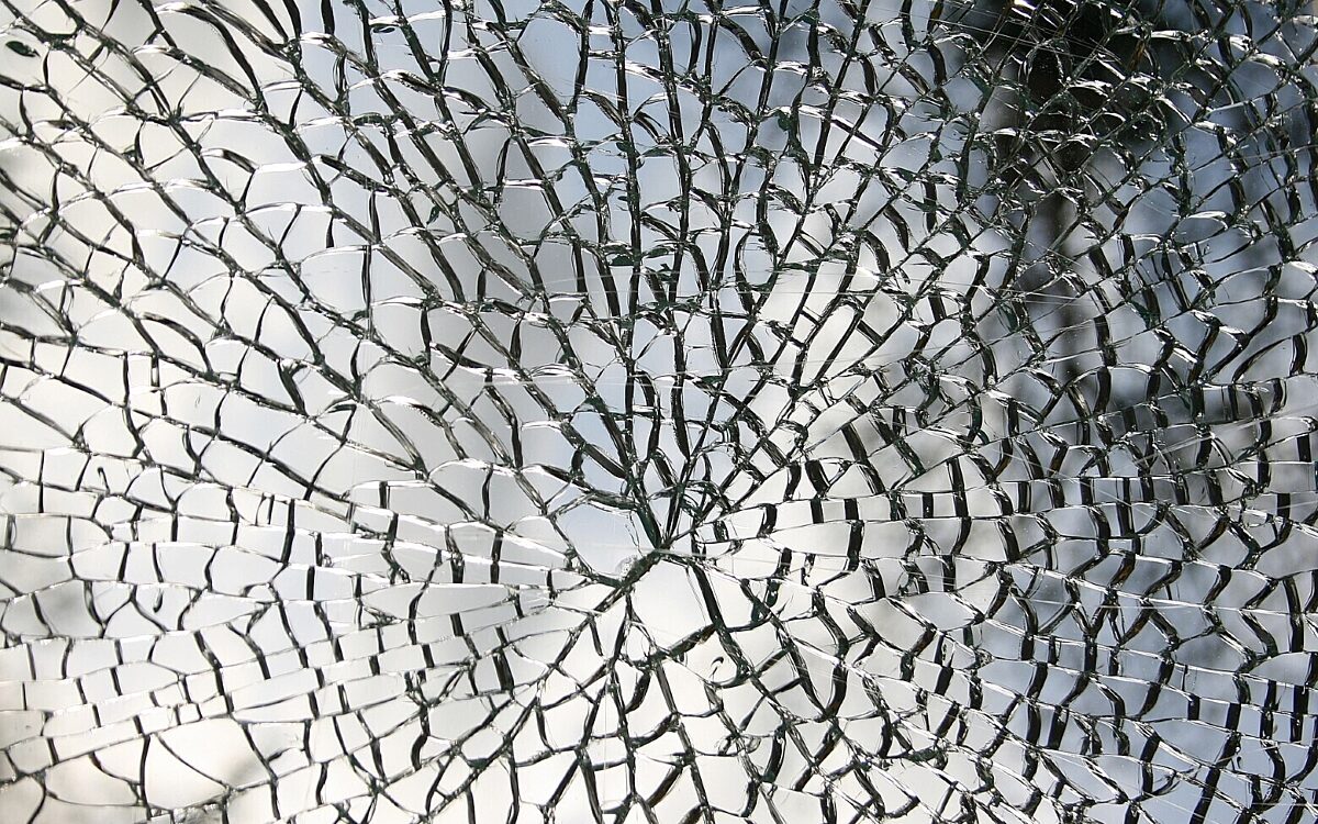 Eine Glasscheibe in einzelne Splitter zerprungen Eine Glasscheibe in einzelne Splitter zerprungen